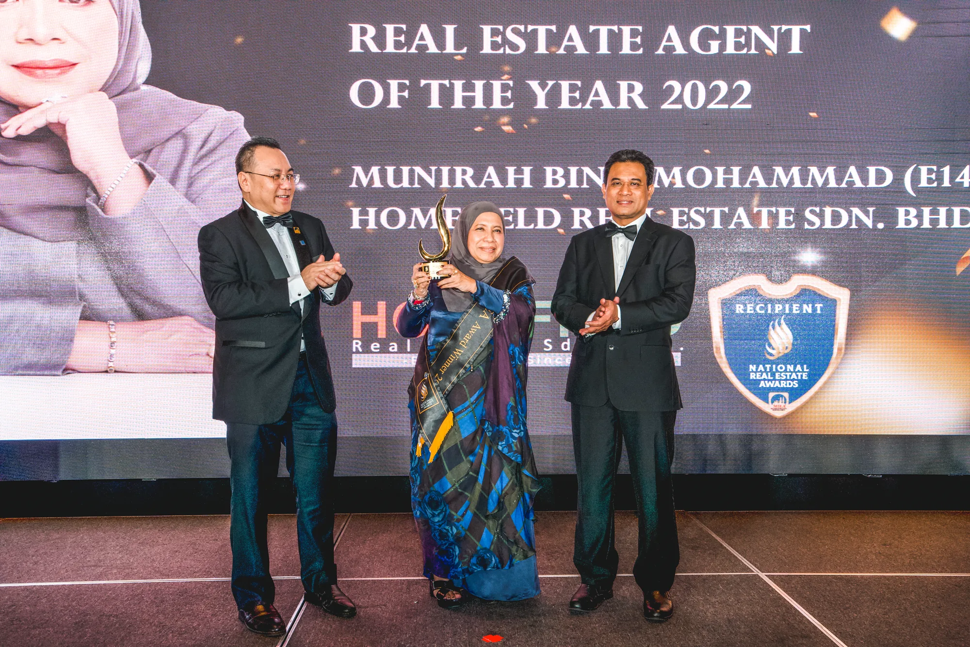 Munirah Mohammad receiving the NREA Real Estate Agent of the Year award on stage in 2022