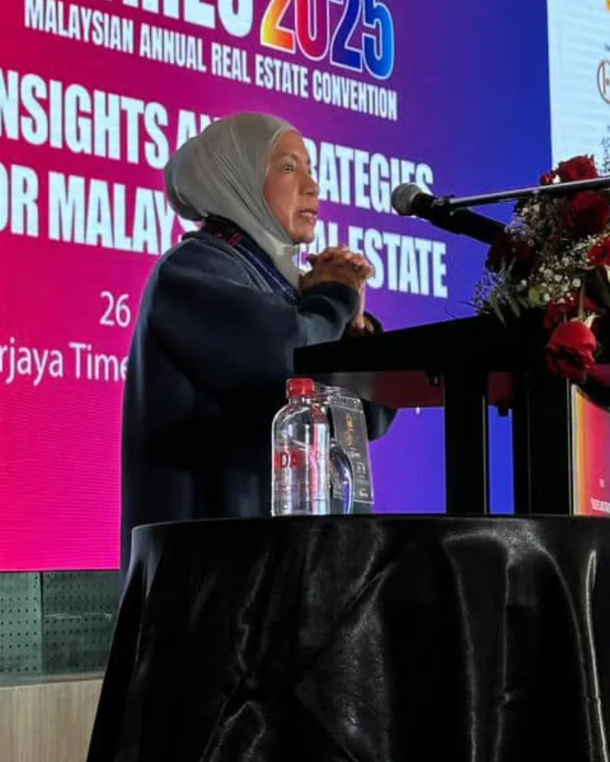Munirah speaking at a podium at the Malaysian Annual Real Estate Convention